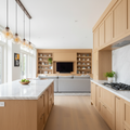 Custom white oak cabinetry suite spanning open-plan kitchen and great room with marble countertops and warm pendant lights